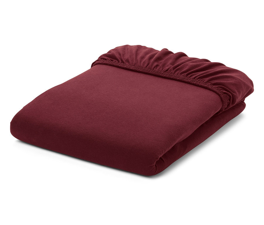 Złożone, bordowe prześcieradło z gumką na białym tle.