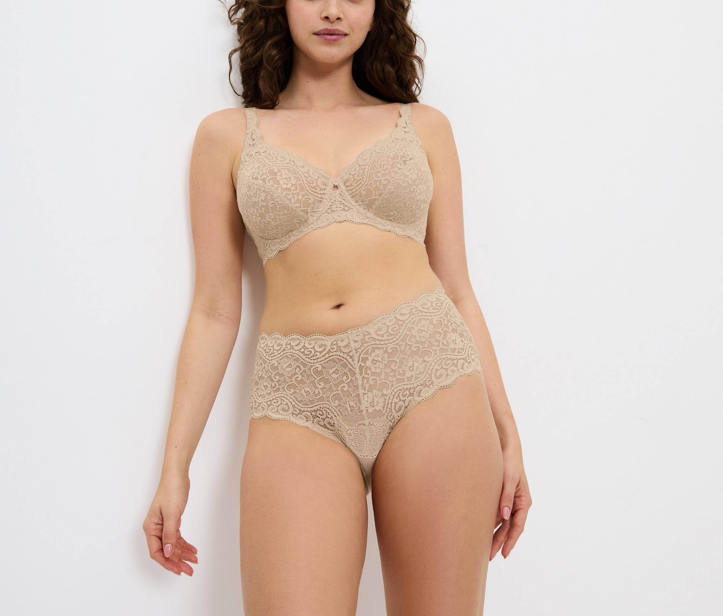 Kobieta pozuje w bieliźnie z kwiatowej koronki.