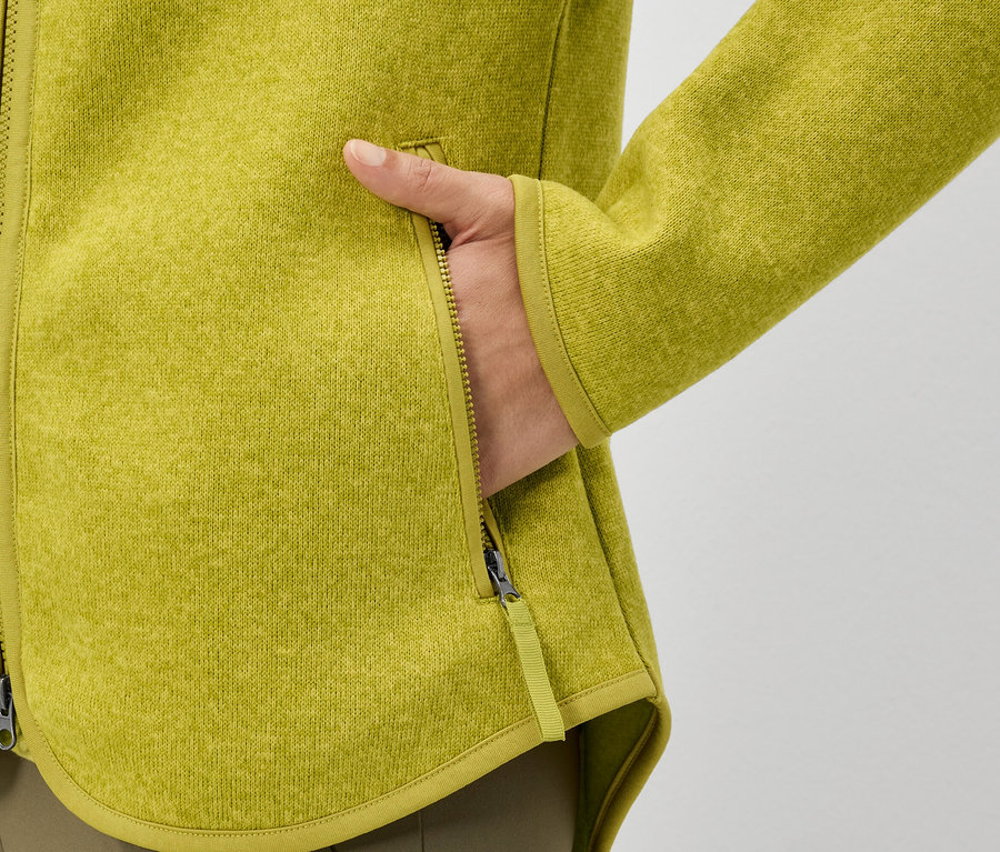 Ręka w kieszeni żółtej bluzy polarowej.