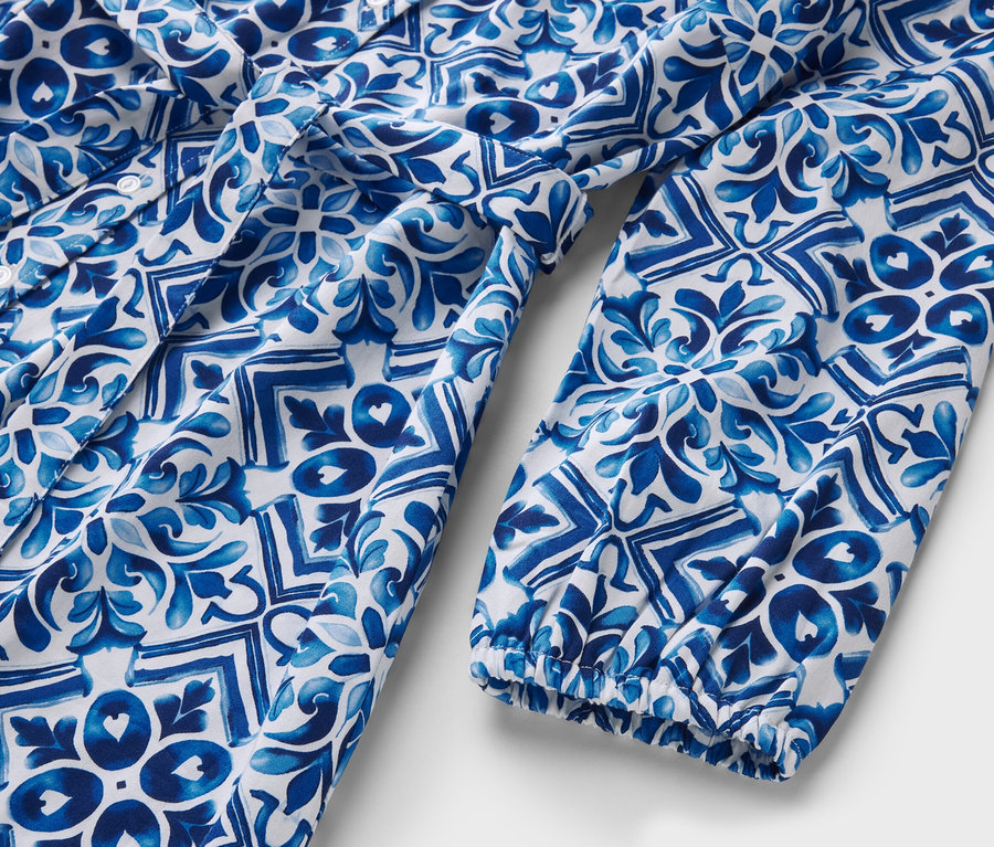 Szczegółowy widok niebiesko-białej sukienki midi z nadrukiem.