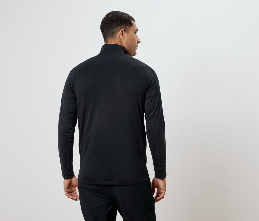 Mężczyzna w czarnej koszulce z długim rękawem i spodniach, odwrócony tyłem.