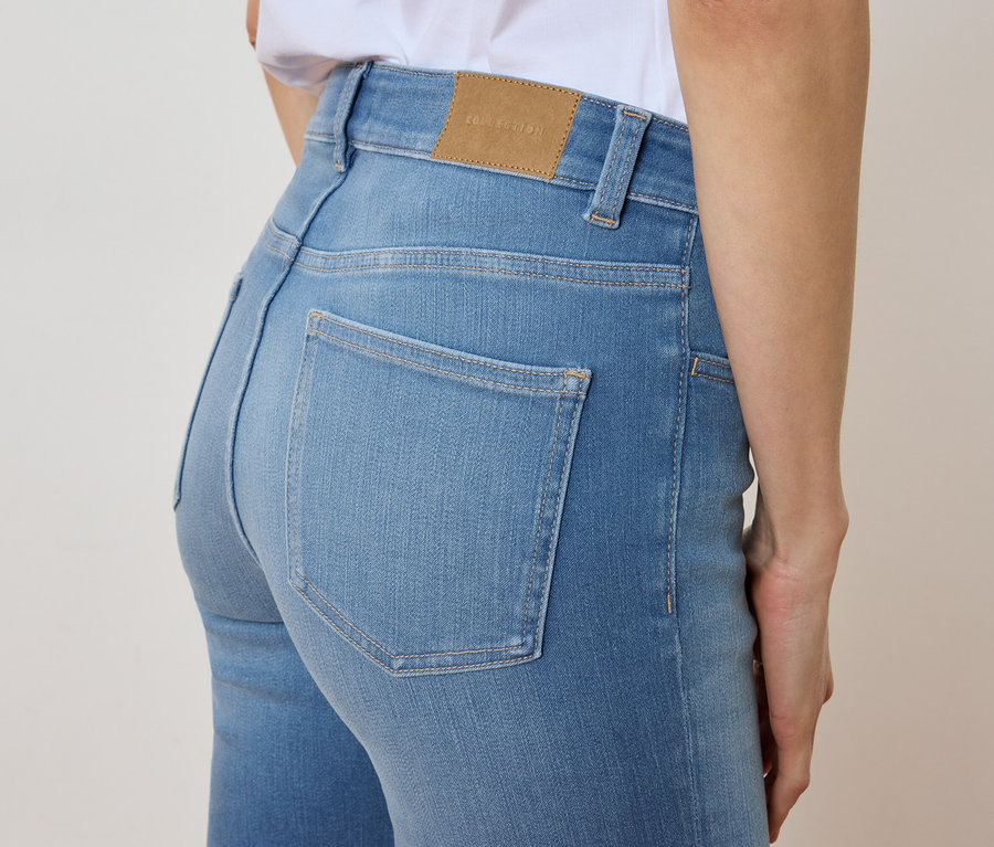 Zbliżenie na kobietę ubraną w jasno-niebieskie dżinsy.