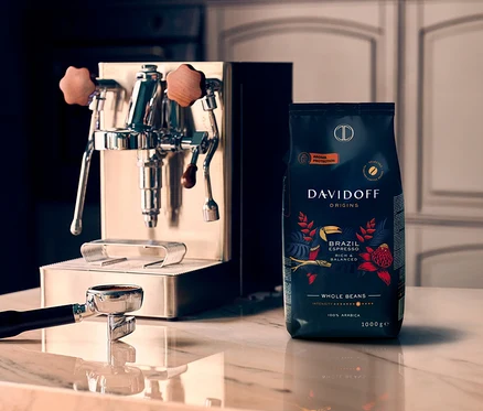 Ekspres do kawy i paczka DAVIDOFF CAFÉ ORIGINS Brazil - 3 x 1 kg Ganze Bohne stoją na marmurowej powierzchni.