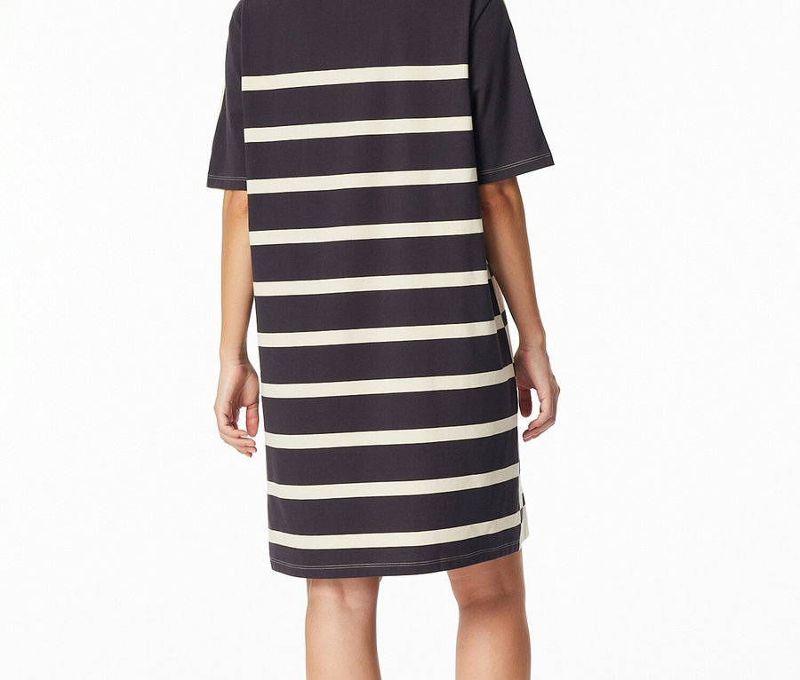 Widok z tyłu kobiety w ciemnoszarej sukience typu T-shirt w poziome kremowe paski.