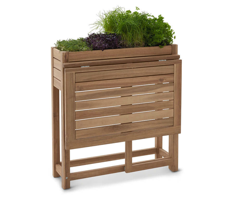 Drewniany podwyższony kwietnik z różnymi ziołami.