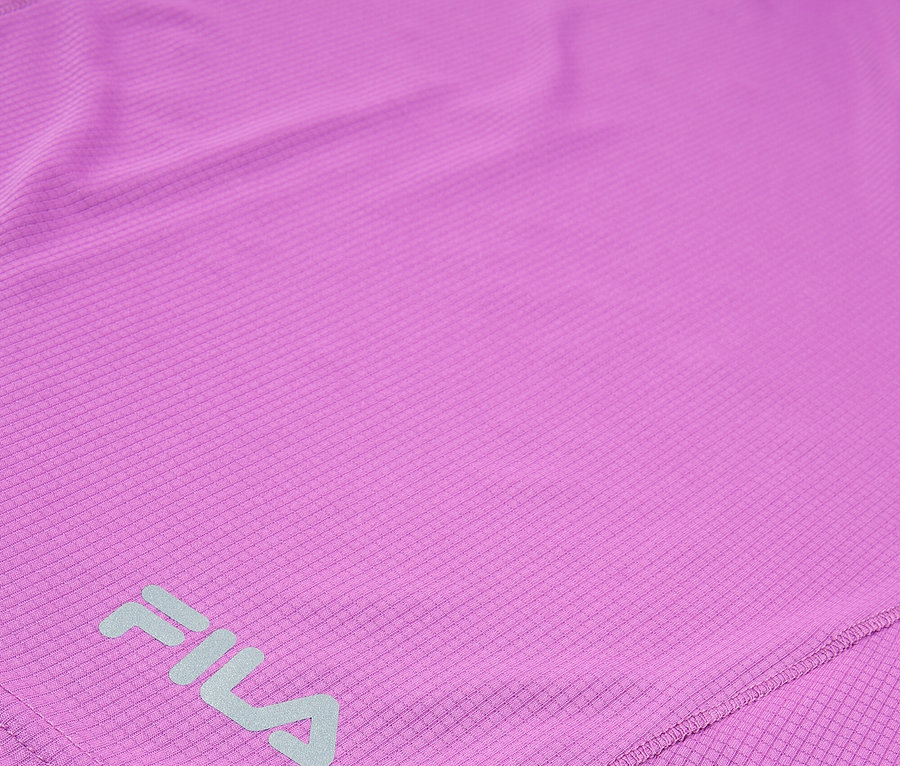 Zbliżenie fioletowej koszulki sportowej Fila z powtarzającym się kwadratowym wzorem.