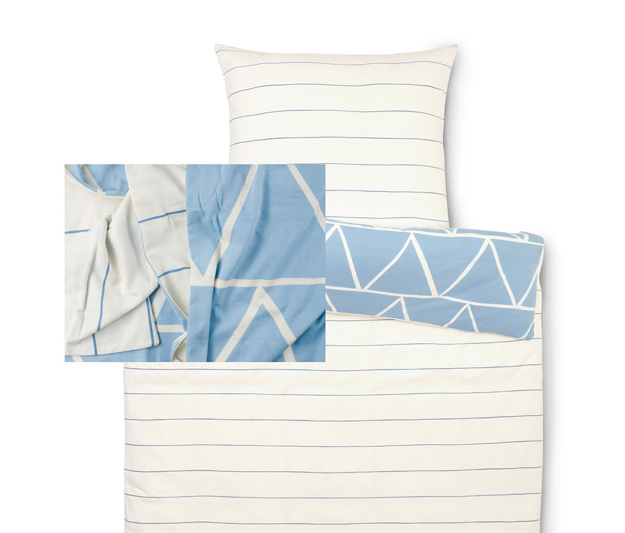 Zestaw pościeli z biało-niebieską poszwą w paski i poszewką na poduszkę w trójkąty.
