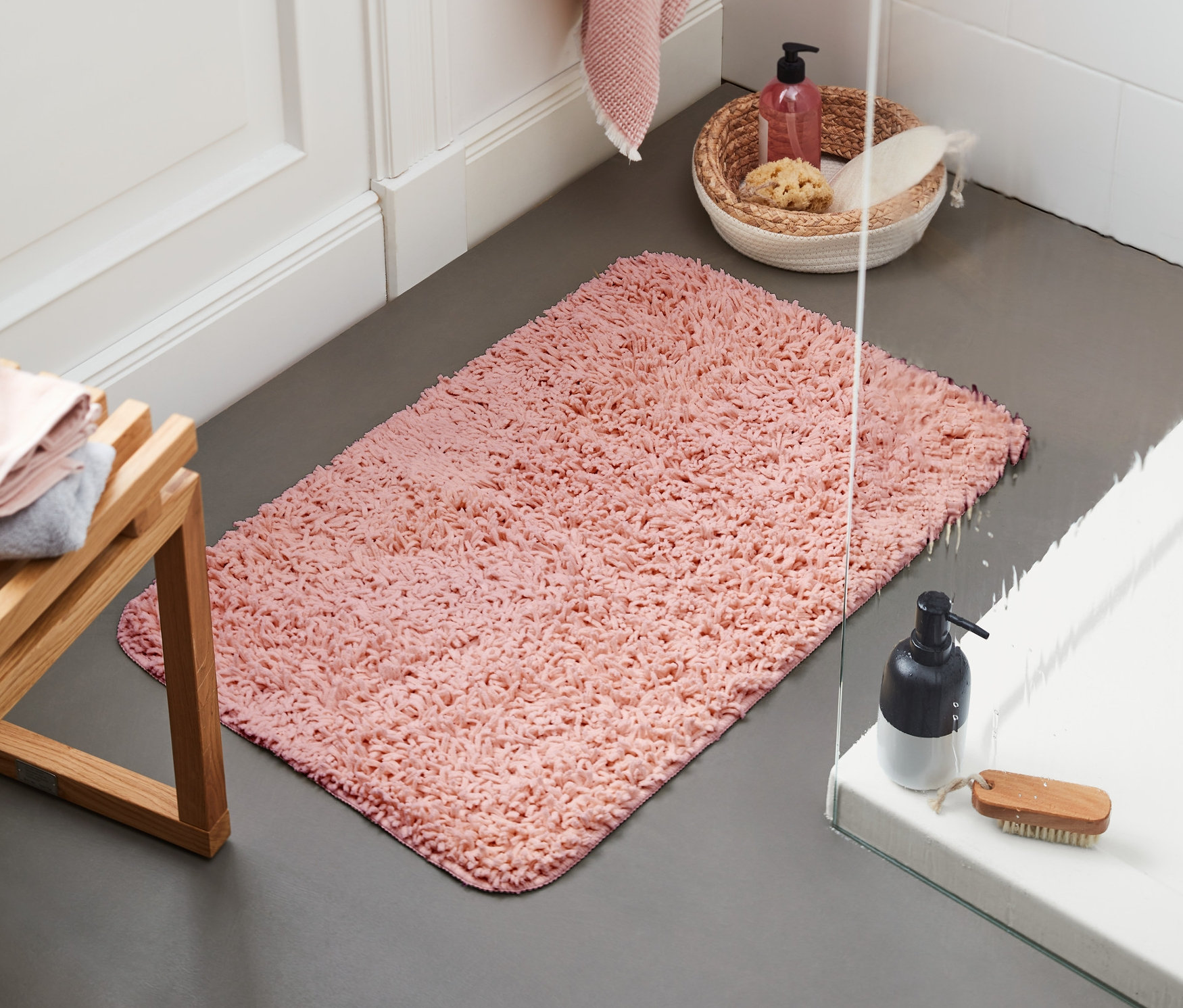 W łazience leży różowa mata łazienkowa z recyklingu o wymiarach ok. 50 x 80 cm.