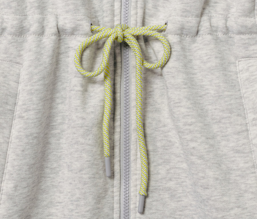 Zbliżenie na szarą, długa bluzę dresową ze sznurkiem.