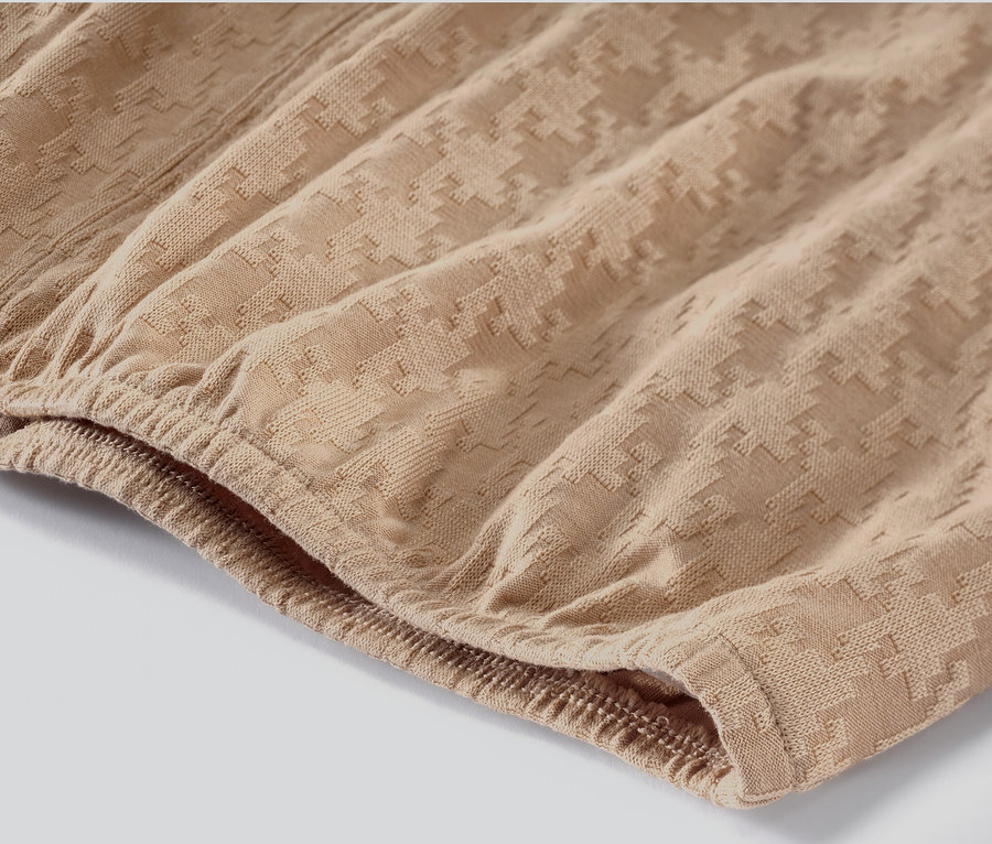 Zbliżenie na karmelową koszulkę z długim rękawem ze strukturą.