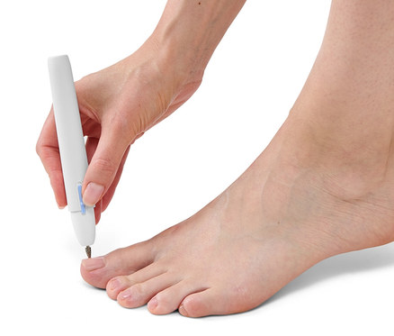Kobieta używa urządzenia do manicure i pedicure na paznokciu u stopy.