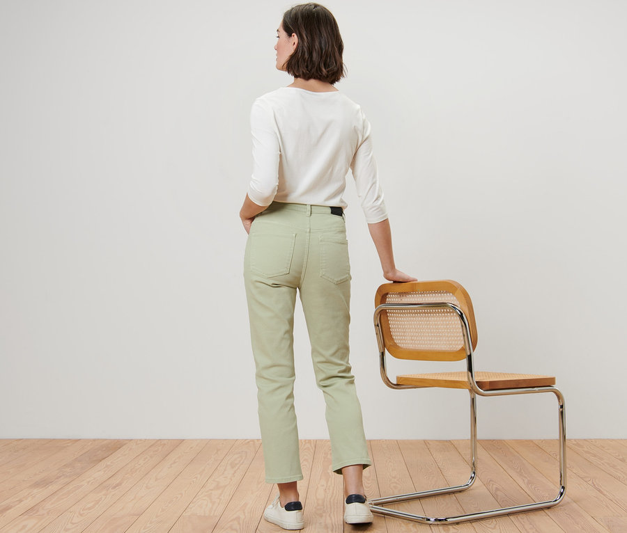 Kobieta pozuje tyłem do kamery w spodniach dżinsowych, fason „Ava”.