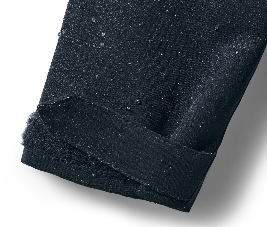 Zbliżenie na rękaw dziecięcej parki przeciwdeszczowej z kroplami wody.