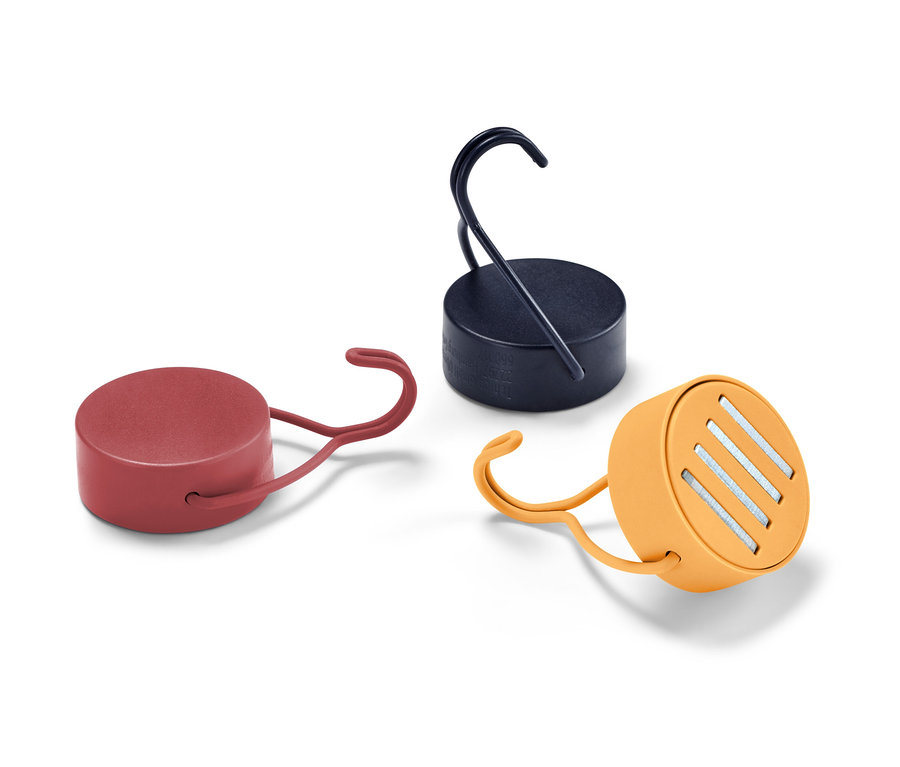 Trzy haczyki magnetyczne w kolorach czerwonym, granatowym i pomarańczowym leżą na białym tle.