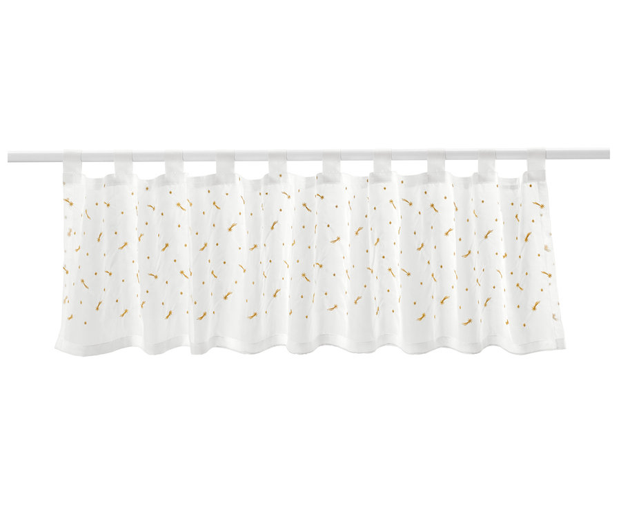 Biała zazdrostka z haftowanymi złotymi spadającymi gwiazdami wisi na białym karniszu.