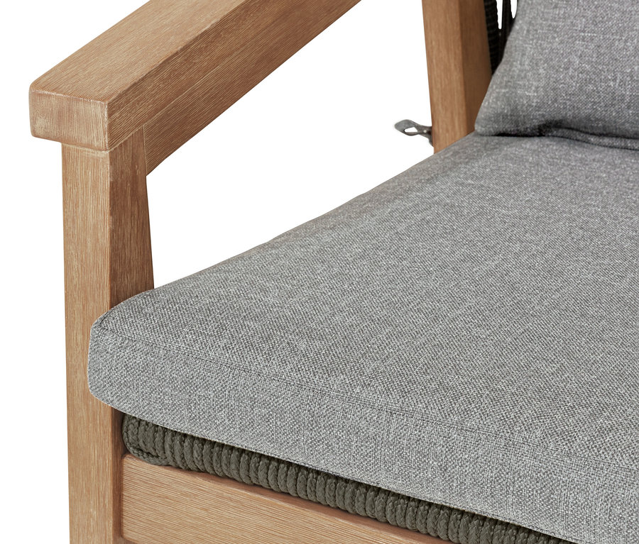 Zbliżenie na fotel z okrągłym oparciem i plecionką tekstylną, siedzisko i oparcie są szare.