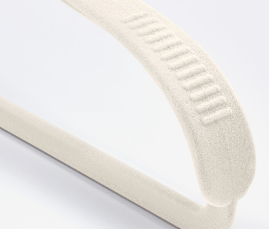 Zbliżenie kremowego, aksamitnego wieszaka z powłoką antypoślizgową na białym tle.