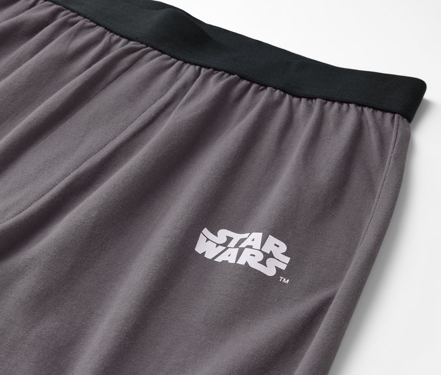 Szczegół szarych spodni z czarnym pasem i logo Star Wars.