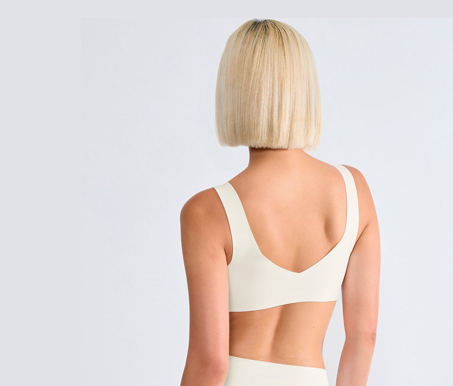 Widok z tyłu blondynki w jedwabiście białym biustonoszu bralette sloggi ZERO Feel 2.0.