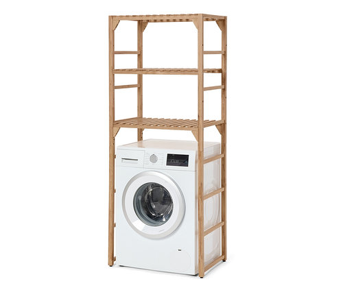 Biała suszarka stoi pod drewnianym regałem na pralkę.