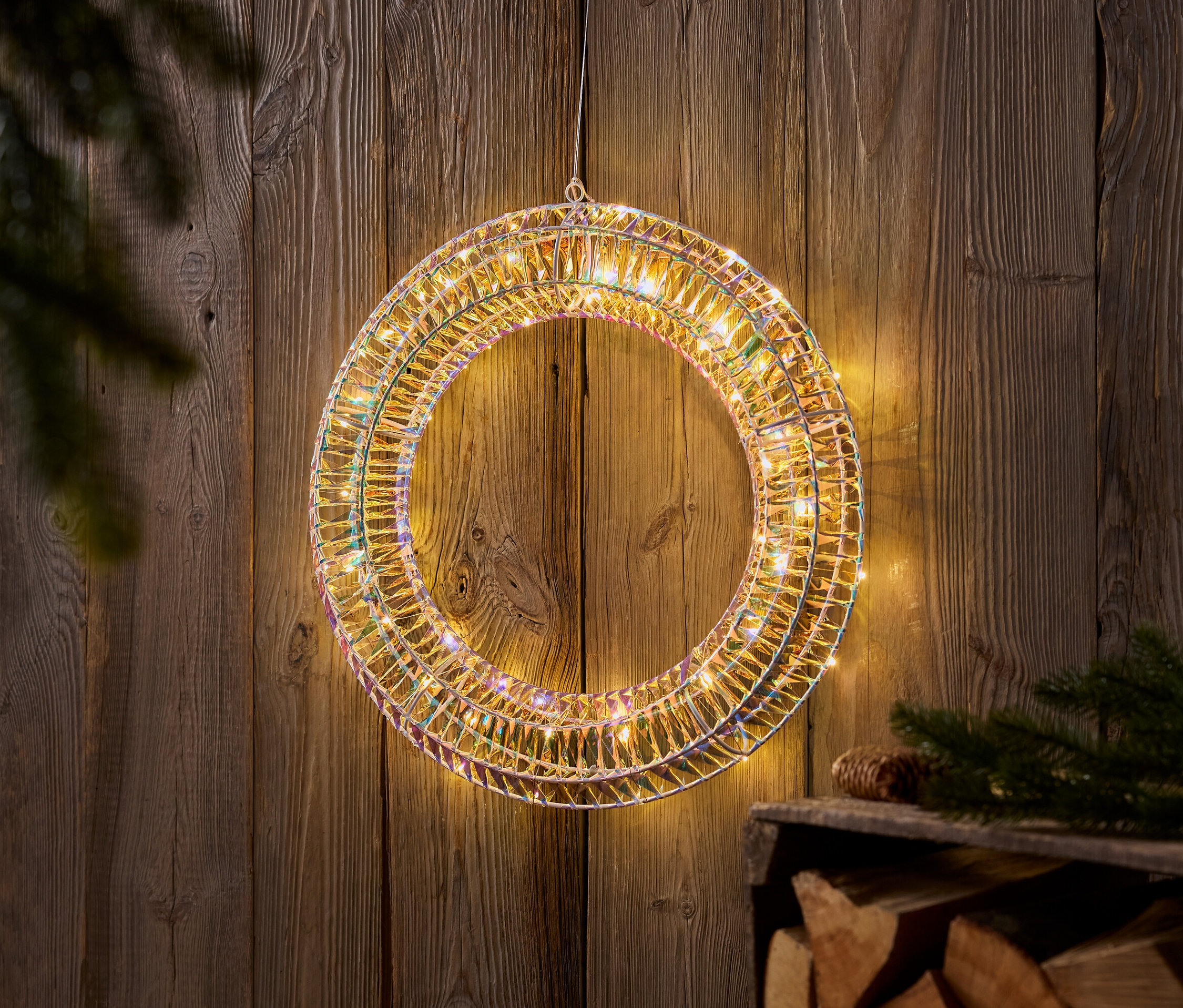 Świecący wieniec wisi na drewnianej ścianie.