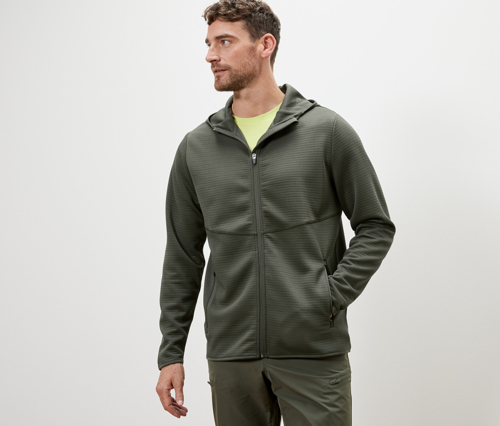 Mężczyzna ma na sobie funkcyjną bluzę w kolorze khaki.