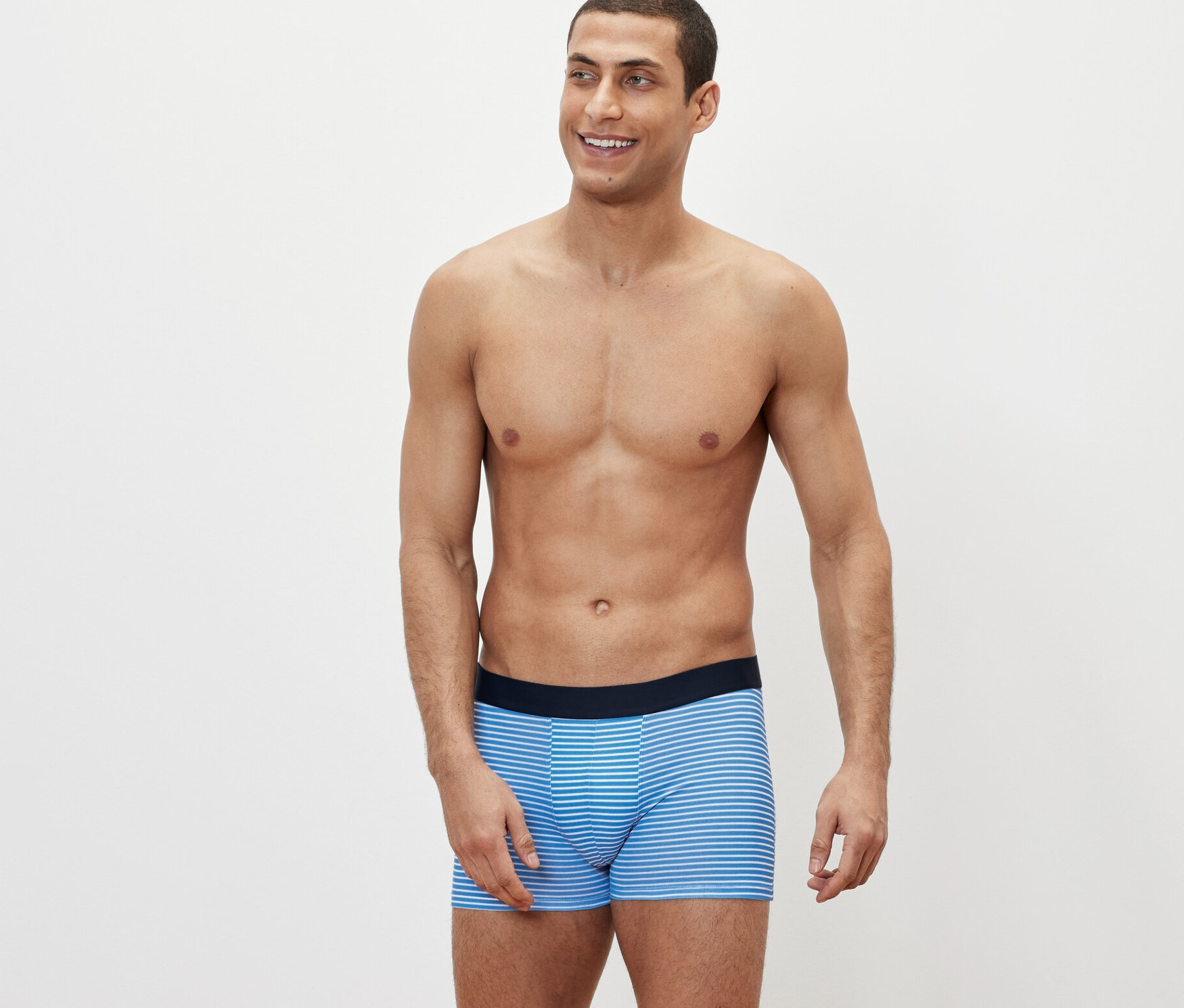 Mężczyzna pozuje w pasiastych bokserkach, 4 pary.