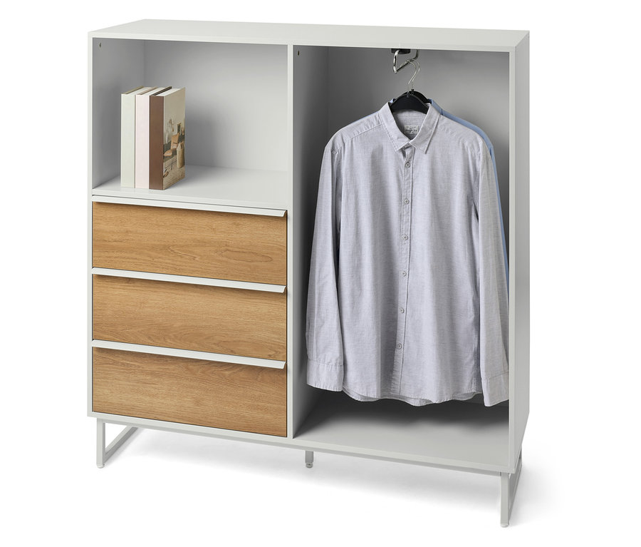 Komoda „LEEG” z 3 szufladami i drążkiem na ubrania, książki i koszula na zdjęciu.