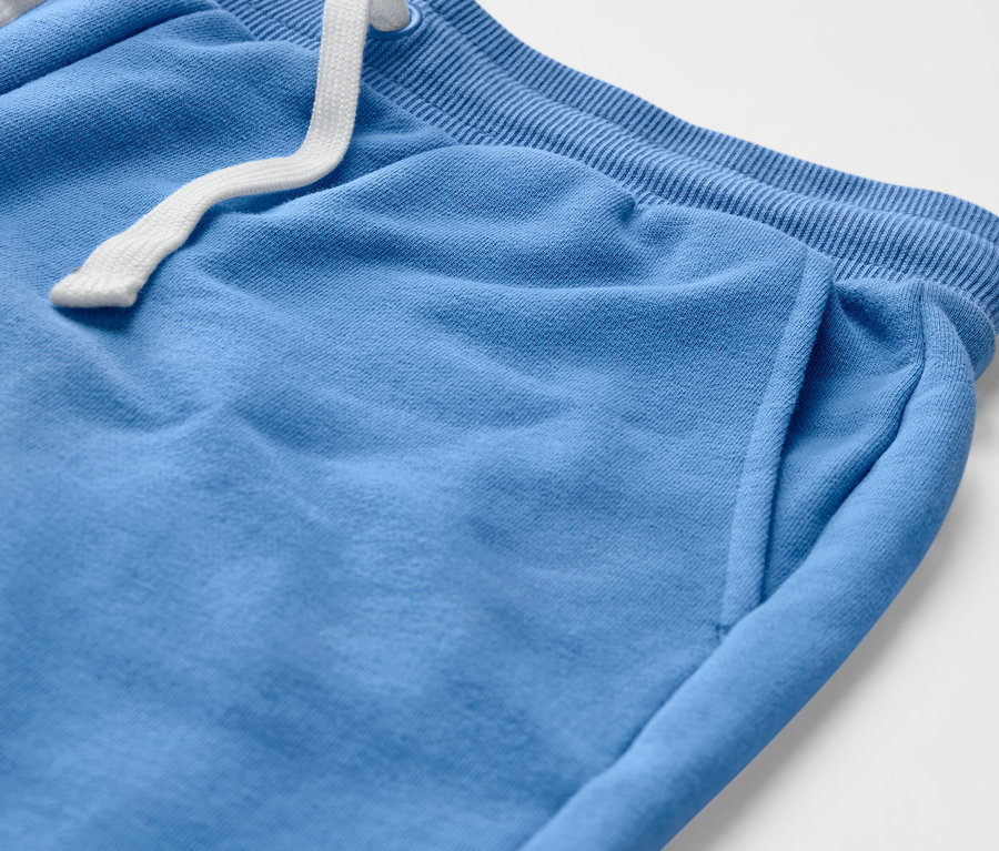 Zbliżenie na jasnoniebieskie spodnie dresowe.