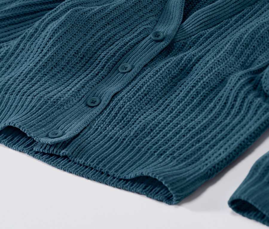 Zbliżenie na petroliowy kardigan zapinany na guziki.