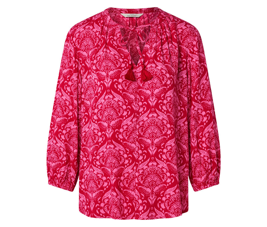 Czerwona bluzka w różowe kwiaty z frędzlami przy dekolcie.