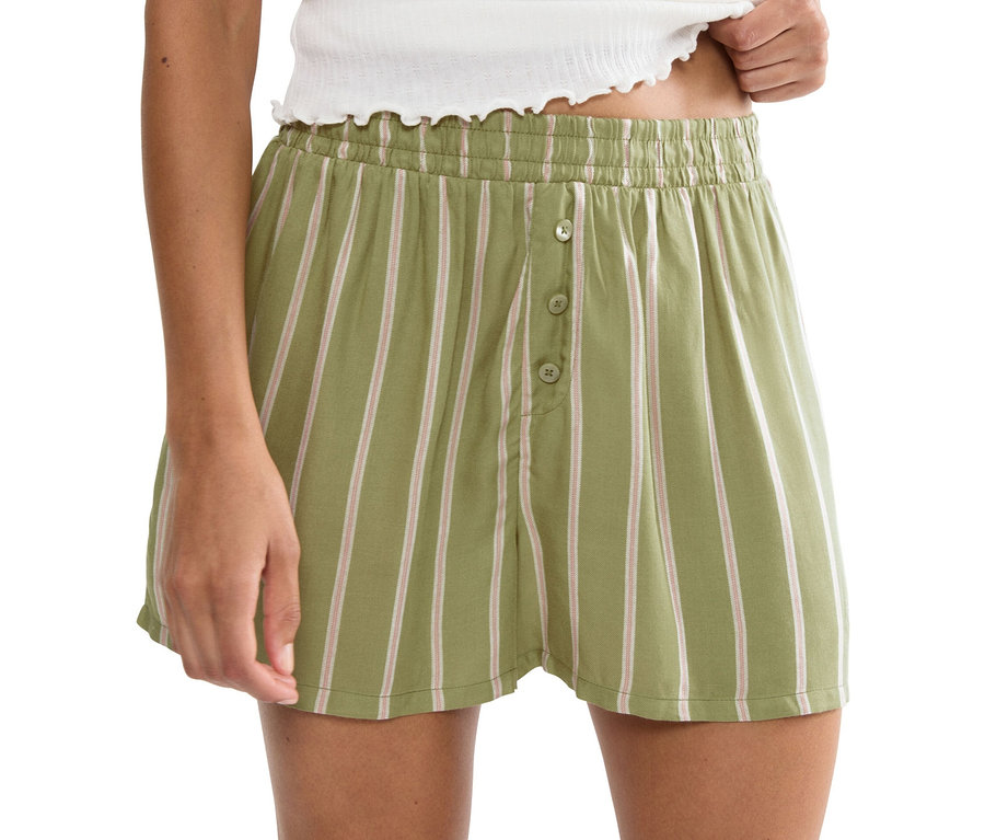 Kobieta ma na sobie szorty w paski z zapięciem na guziki.