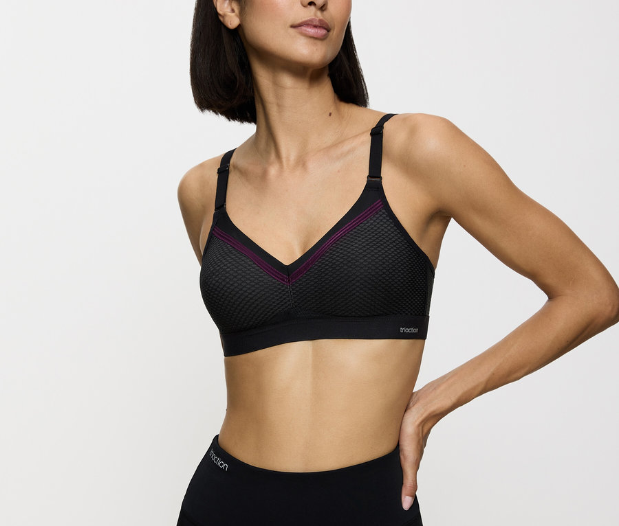 Kobieta ma na sobie czarny biustonosz sportowy i legginsy.