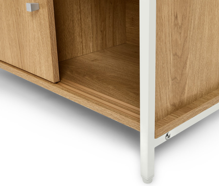 Szczegółowy widok jasnobrązowej drewnianej szafki z białymi nóżkami.