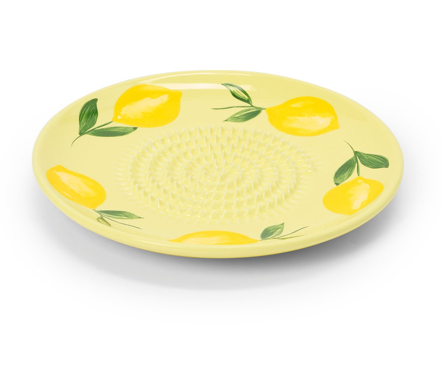 Żółta ceramiczna tarka z motywem cytrynowym leży na białym tle.