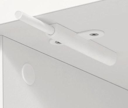 Detal białego mebla z mechanizmem otwierania.