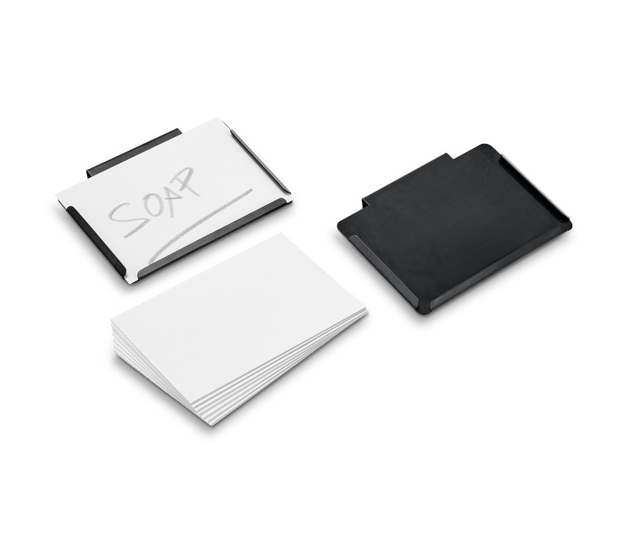 Dwa klipsy metalowe, jeden z kartką i napisem SOAP, drugi czarny, obok leży stos białego papieru.