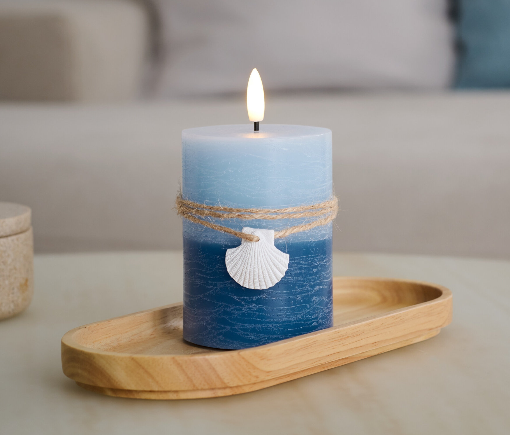 Niebieska świeca LED z prawdziwego wosku „Muszelka” na drewnianej tacy.