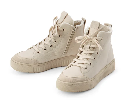 Dwa beżowe ocieplane buty typu sneakers ze skóry na białym tle.