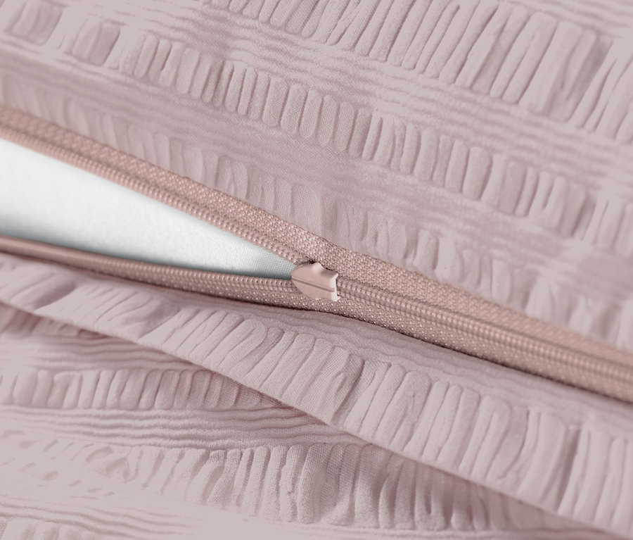 Zbliżenie na bladoróżową pościel z kory z zamkiem błyskawicznym.