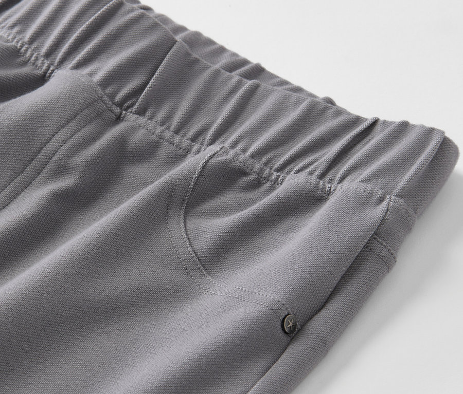 Zbliżenie na szare legginsy stylizowane na dżinsy, z gumką w pasie i kieszenią.