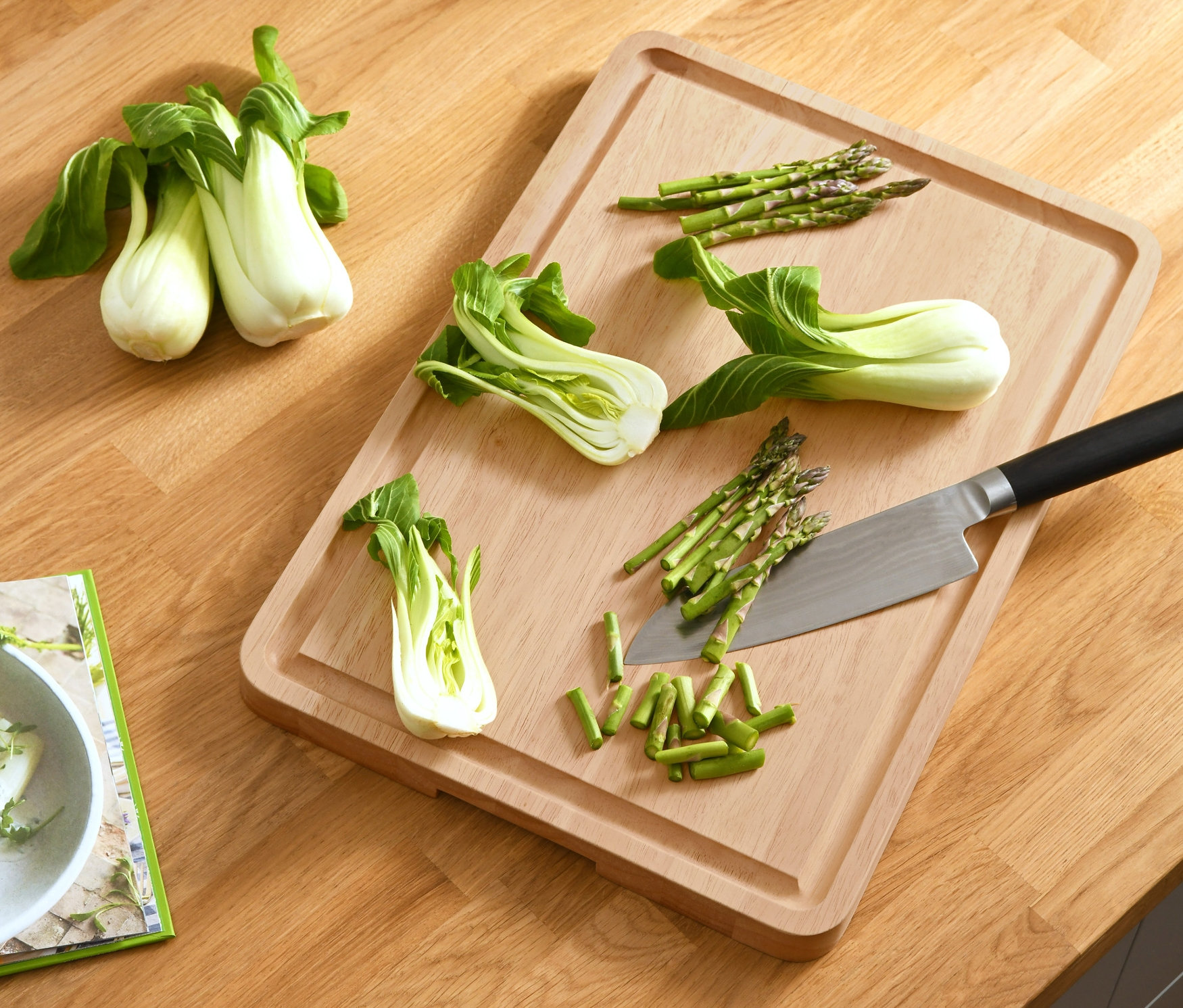 Na drewnianej desce do krojenia leżą warzywa i nóż.