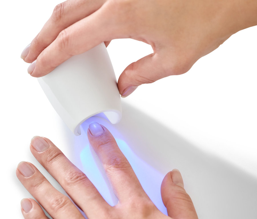Kobieta używa lampy UV z zestawu do manicure i pedicure 5 w 1.