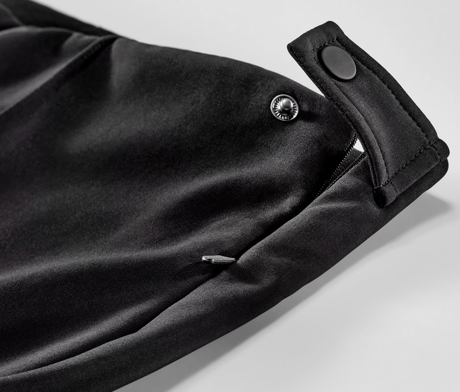 Szczegół narciarskich obcisłych spodni softshellowych z kieszenią na zamek błyskawiczny i zatrzaskami.