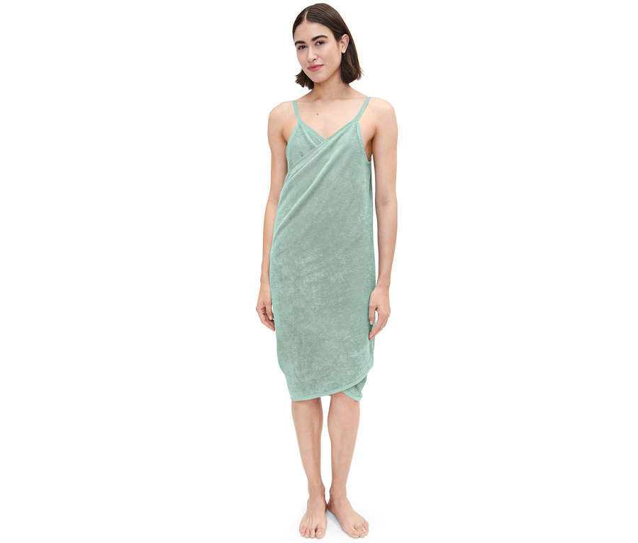 Kobieta ma na sobie zielony ręcznik-sukienkę.