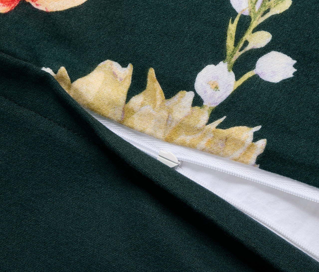 Zbliżenie na zieloną pościel z flaneli o standardowym rozmiarze, z kwiatowym wzorem i zamkiem błyskawicznym.