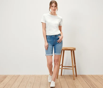 Kobieta pozuje w dżinsach bermudach – fason „Lea”, light blue denim.