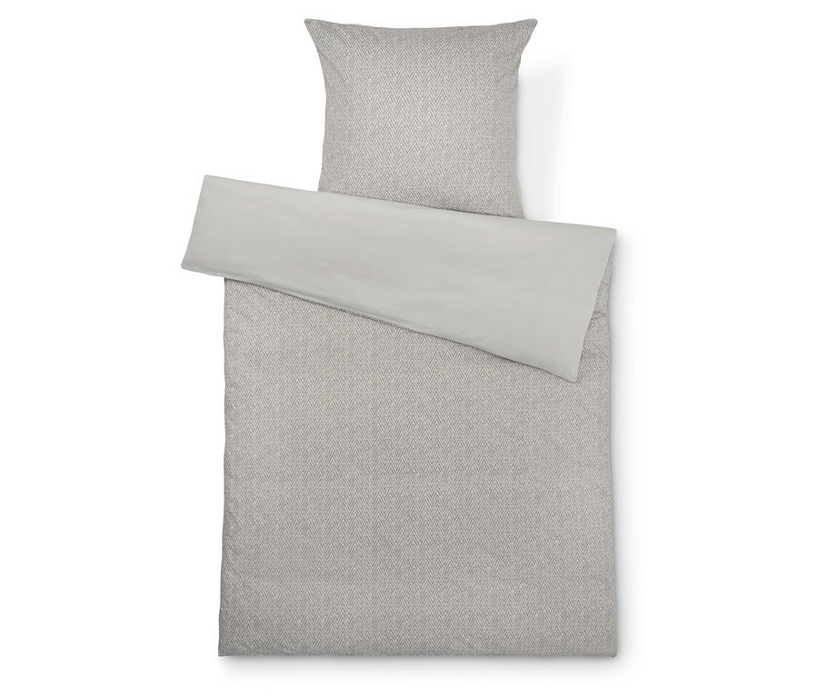 Pościel w geometryczny wzór z jasno szarą narzutą.