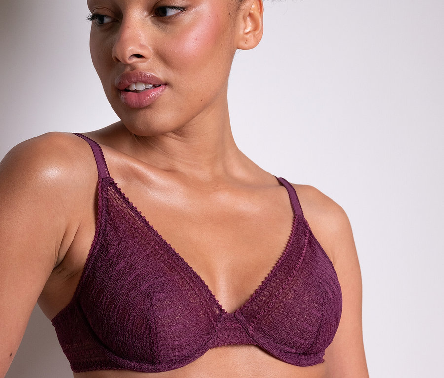 Kobieta ma na sobie biustonosz z fiszbinami Passionata „Leila” w kolorze fioletowym.