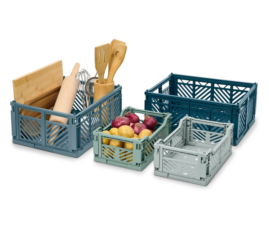 Cztery składane skrzynki w różnych rozmiarach i kolorach, jedna z przyborami kuchennymi, jedna z ziemniakami.